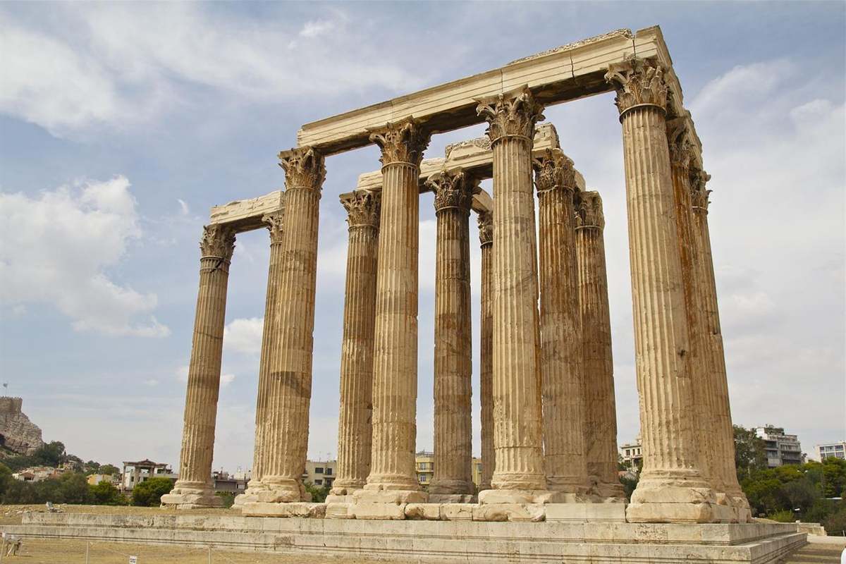 Aegean Voyager Greece tour: the tall Corinthian columns of the Temple of Olympian Zeus in Athens against a blue sky with scattered clouds